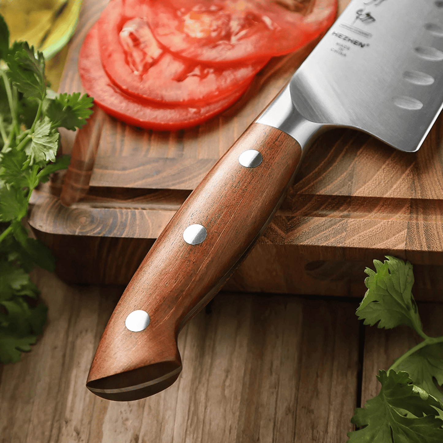 Wooden-handled knife on a wooden cutting board with sliced tomatoes and herbs