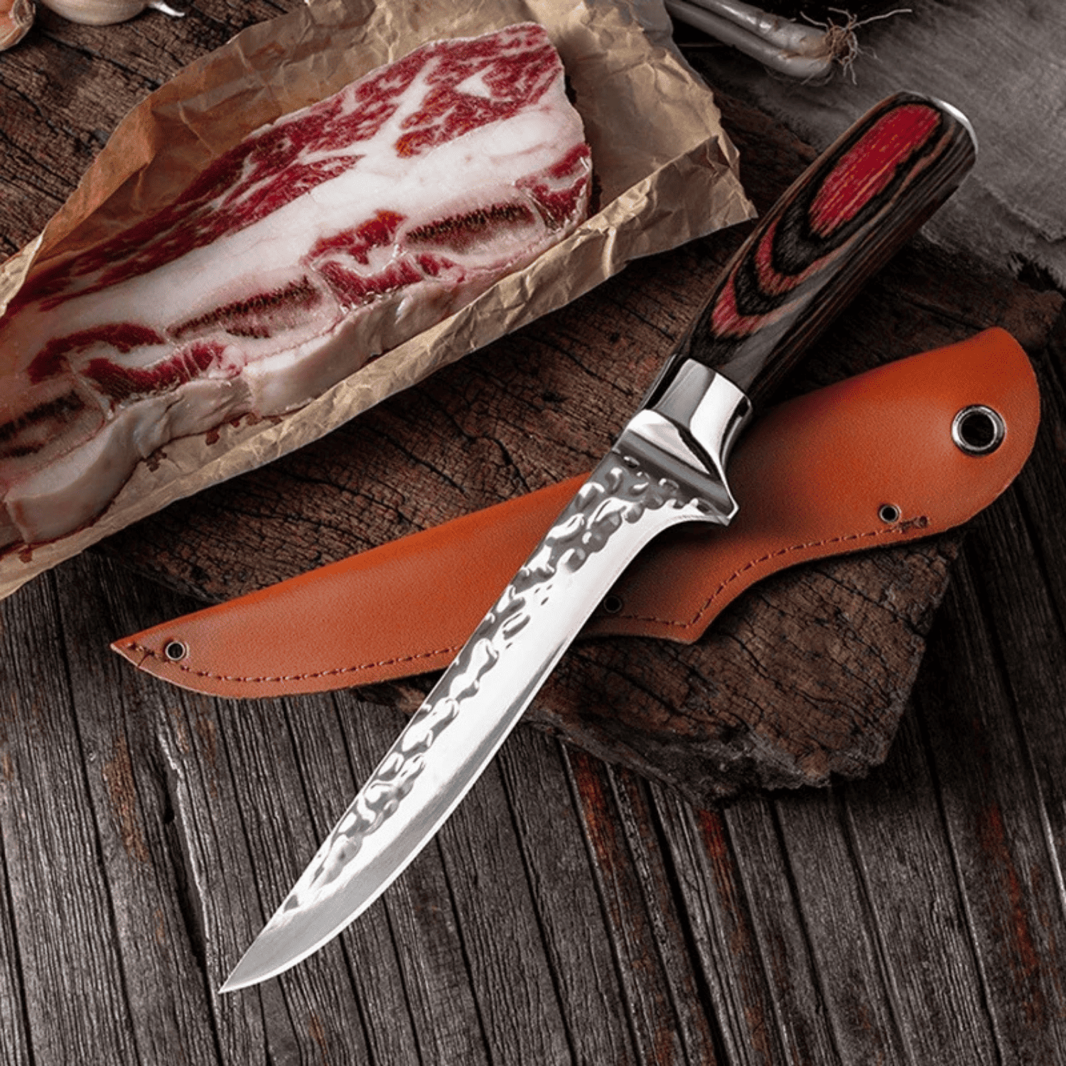 Decorative knife with a leather sheath on a wooden surface next to raw meat.