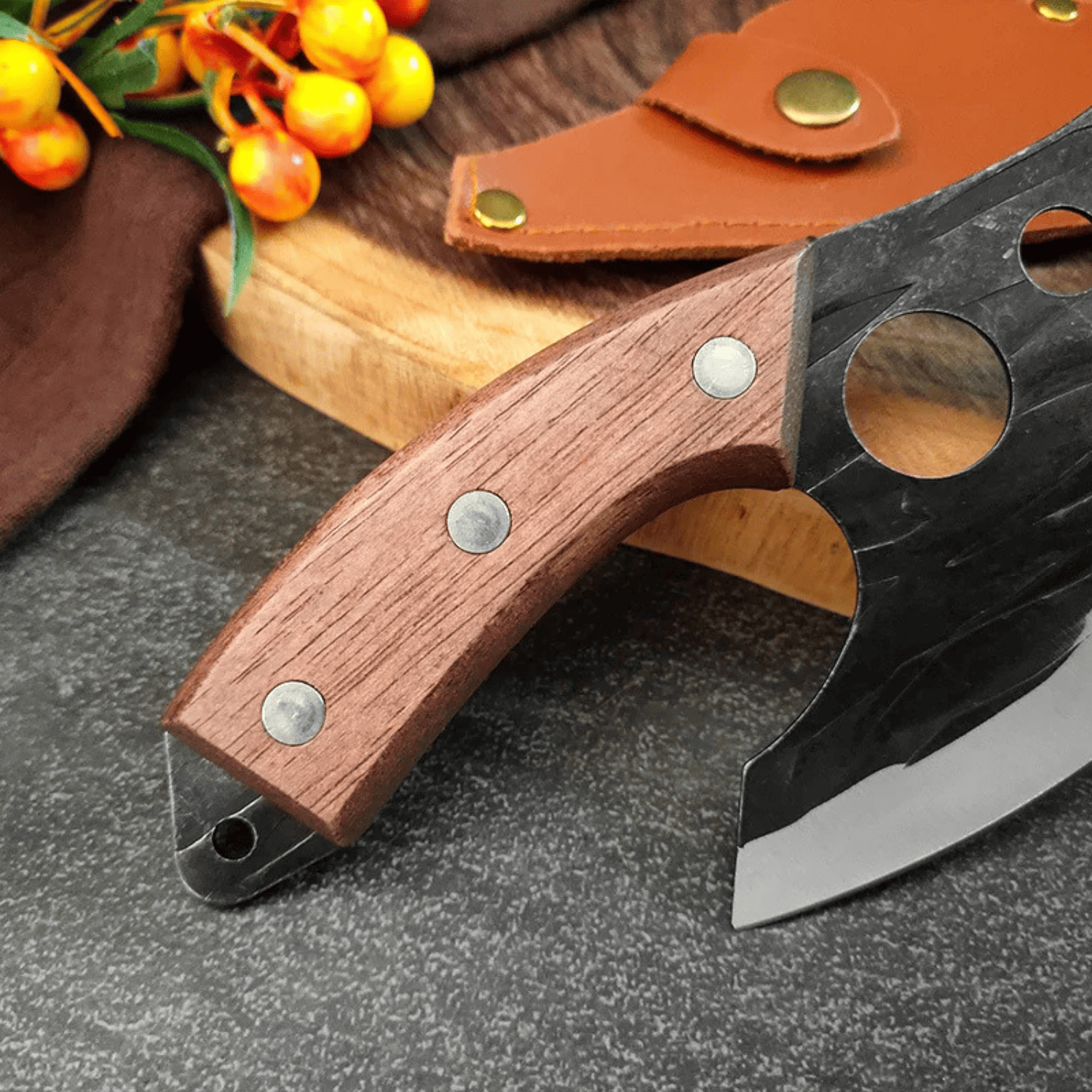 Knife with wooden handle and leather sheath on a dark surface