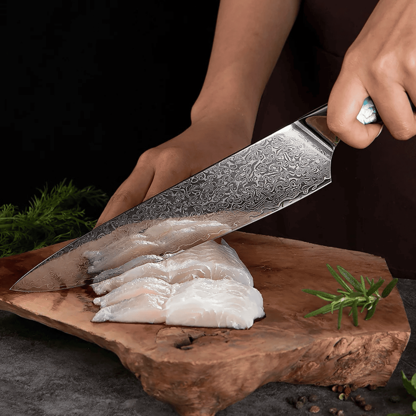 Person cutting fish fillets on a wooden board with a decorative knife.
