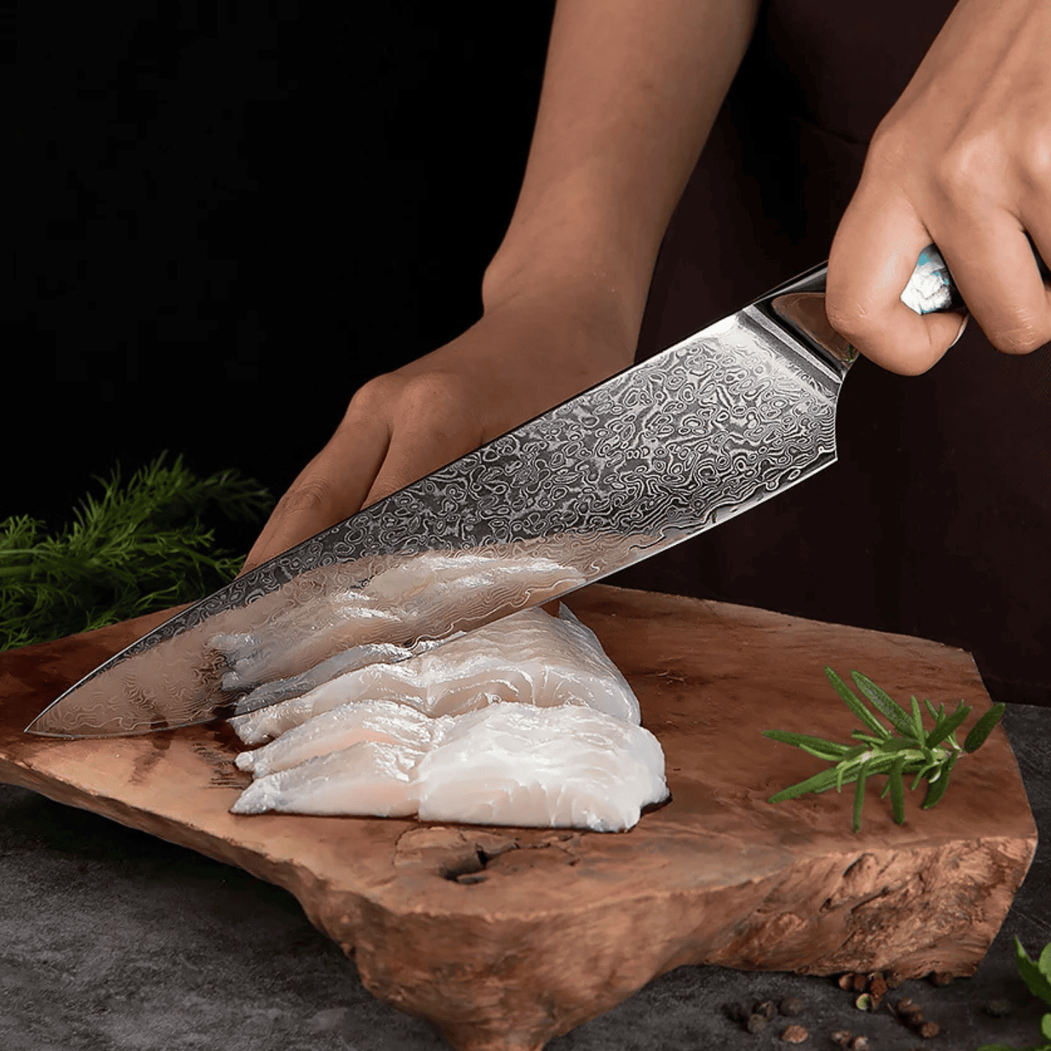 Person cutting fish fillets on a wooden board with a decorative knife.